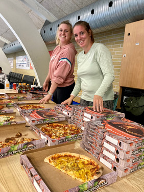2 lærere klar til at udlevere pizza til eleverne